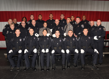 13 police recruits pose with PD command staff after their badge pinning ceremony